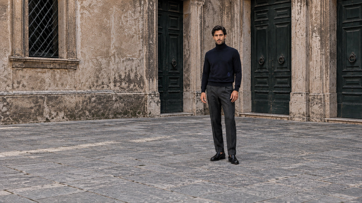 Autumn Italian knitwear editorial with a man in a navy turtleneck and tailored trousers